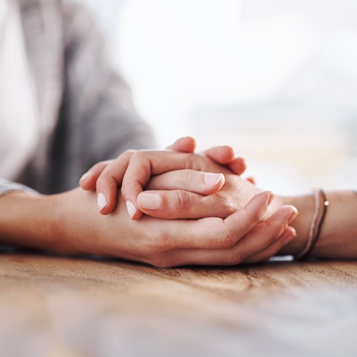 Closeup shot of two unrecognisable people holding hands in comfort